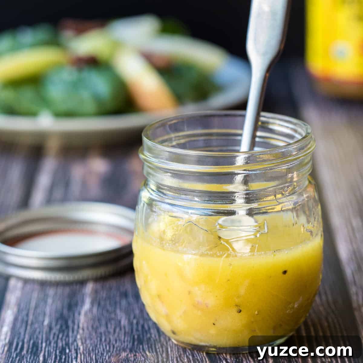 jar of apple cider vinegar salad dressing with salad in background