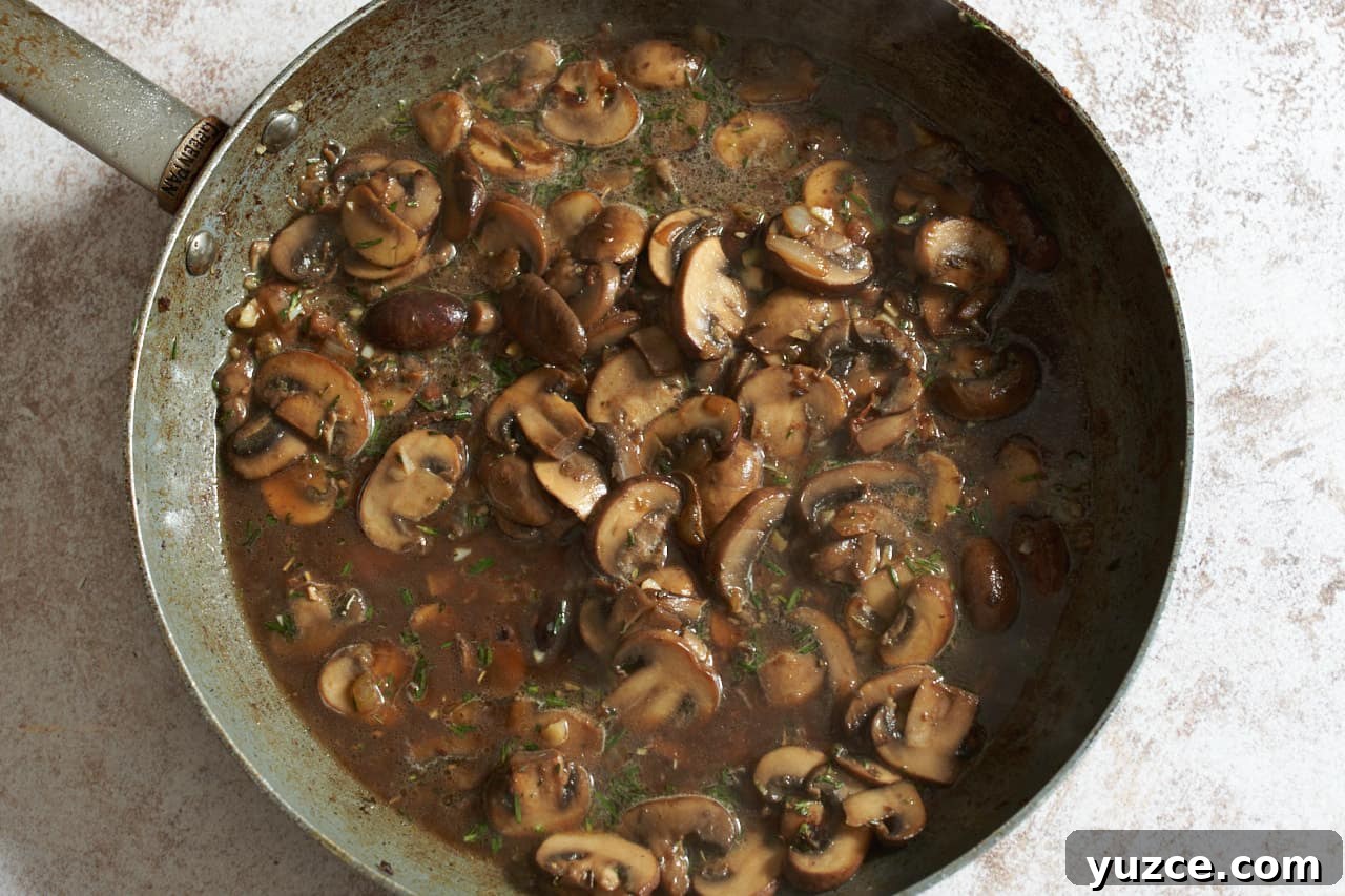 Slow Cooker Chicken Cacciatore Recipe for Tender, Flavorful Meals 7 Mushrooms in broth in a skillet.