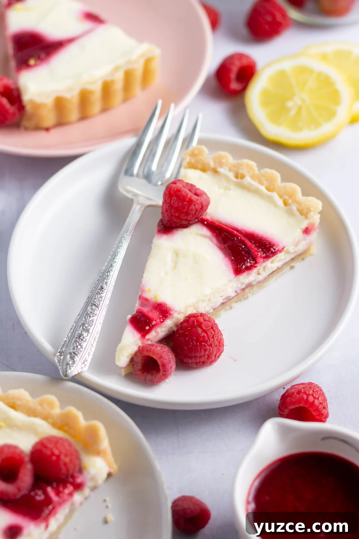 Lemon Raspberry Tart Recipe with a Buttery Shortcrust 6 slice of lemon raspberry tart on a plate with a fork
